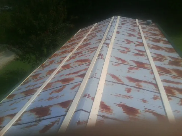 Rusted metal roof panels with new wood purlins before replacement — Storm Damage Roof Repair in Waller by Roofing Brothers