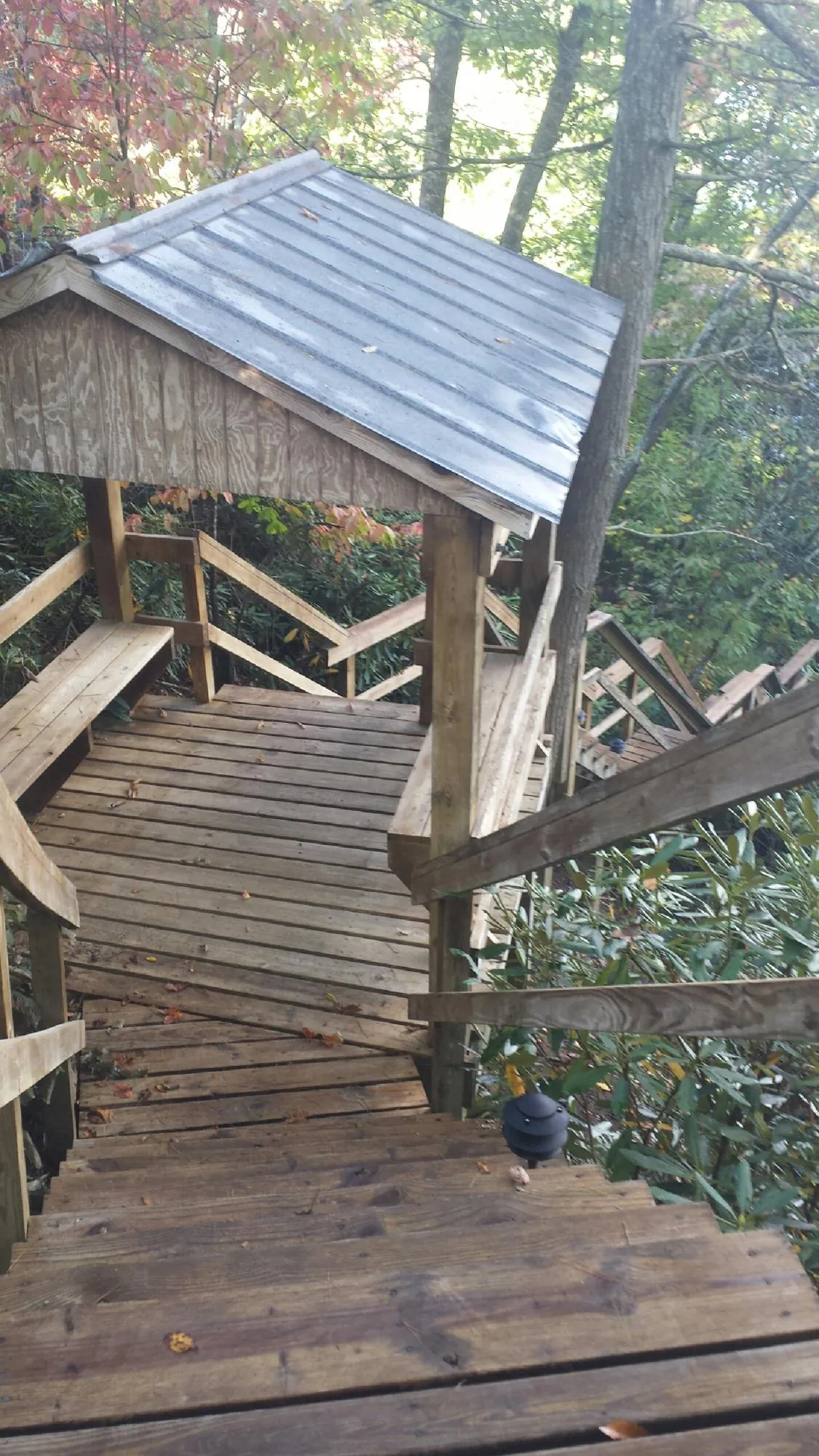 Metal roofed shelter over wooden steps on a wooded walkway — Skylight Repair & Installation work by our crew in Waller